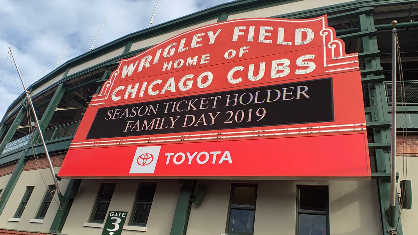 A close up photo of the red Wrigley Field sign, stating "Home of the Cubs"