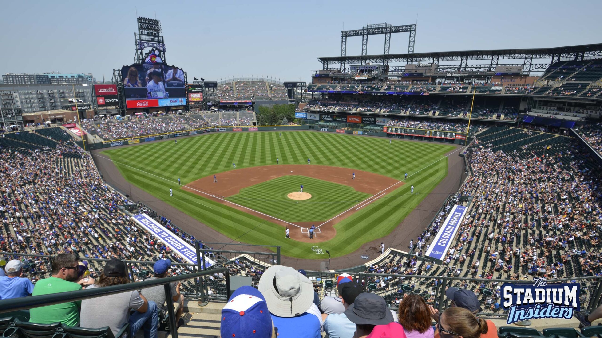 The view of Coors Field, full of fans, from just behind home plate on the 300 level