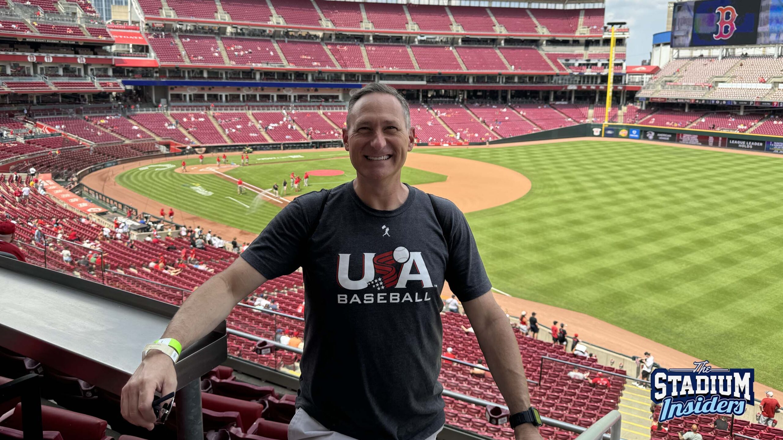 Great American Ball Park Stadium Insider Mike Regent stands in the seating area in front of the ballpark's field